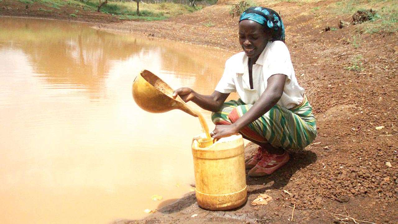A woman fetching water amid water scarcity.