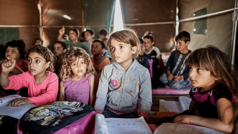 Syrian refugee children attend a class at a makeshift school during Syria war.
