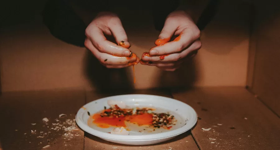 Hands grabbing food messily in a box